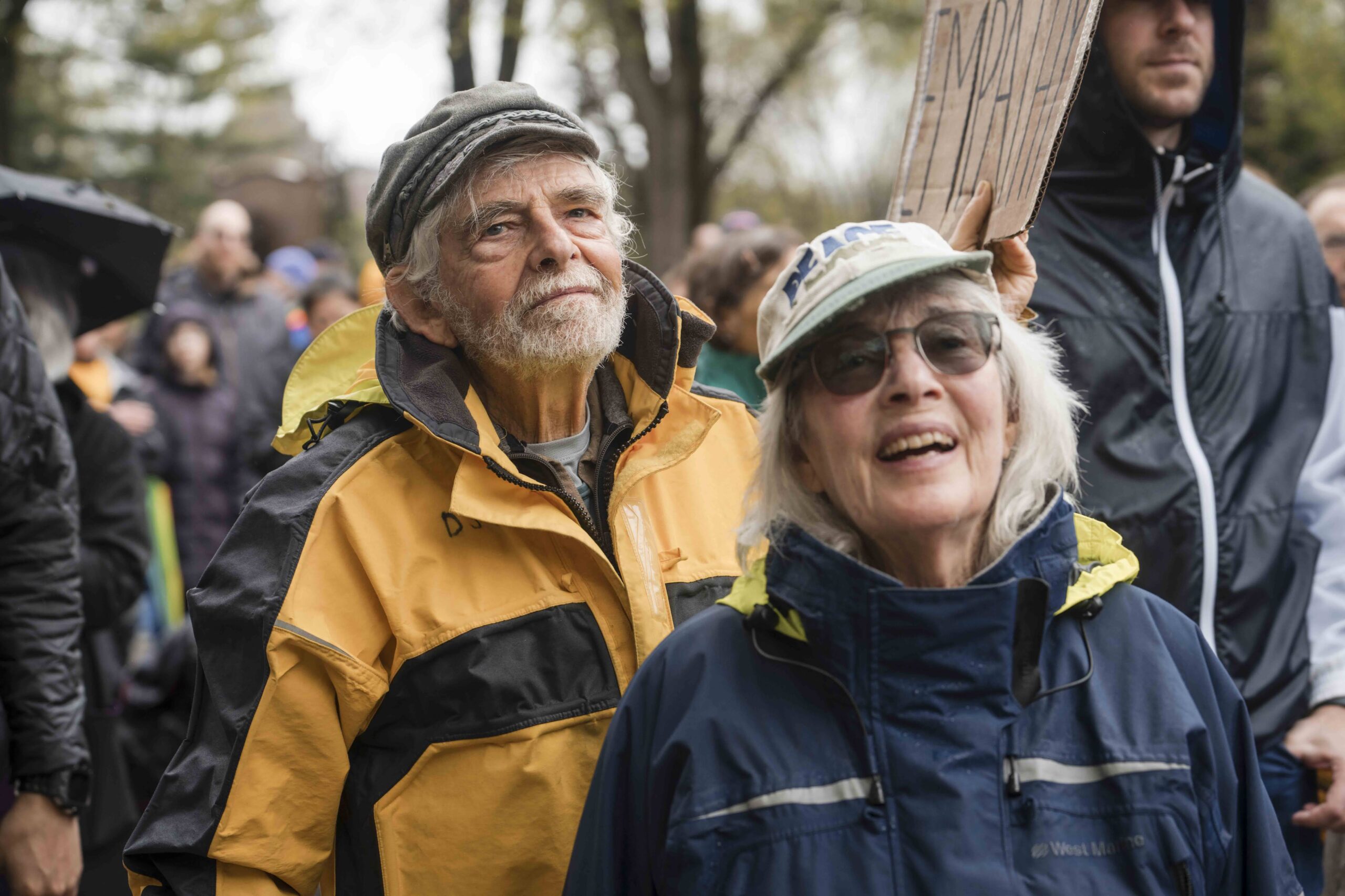 Two people in rain coats outside at the Embrace Freedom Rally