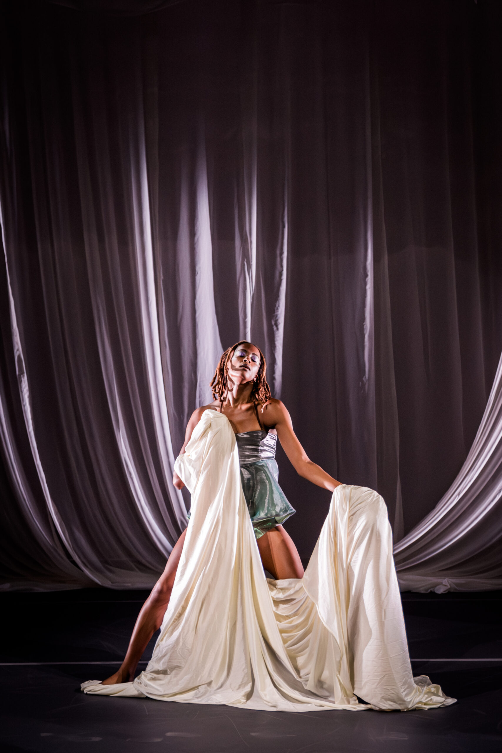 A performer on stage holding white fabric
